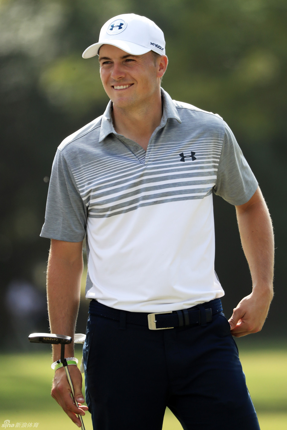 日本名将松山英树在全神贯注地挥杆击球，他的动作流畅而有力，摄影师在一旁竭力捕捉这个完美的瞬间，展现了顶级球员的技术魅力与赛事记录的专业性。