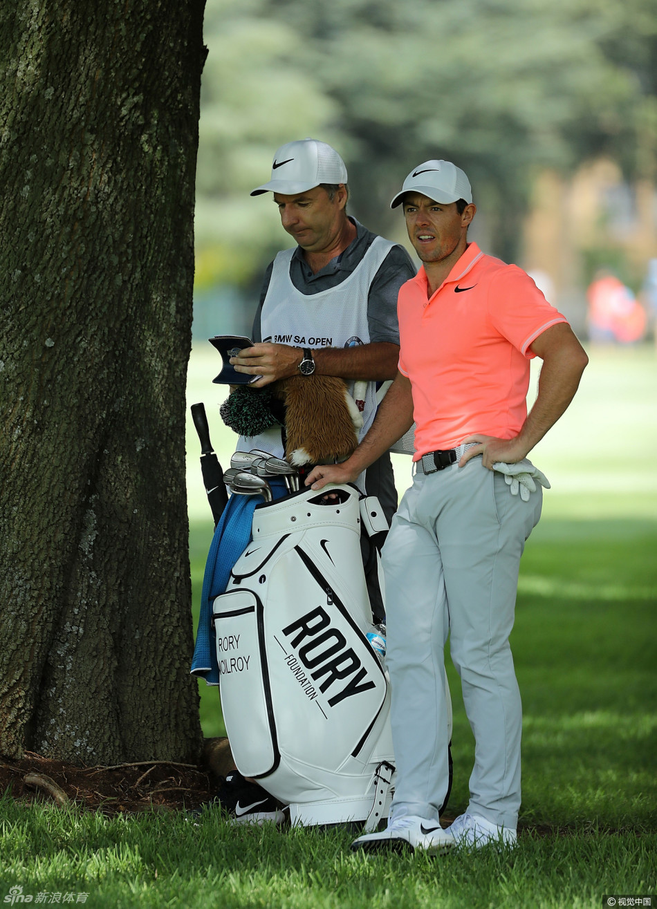 麦克罗伊在果岭上单膝跪地,用手指细致地比划着推杆线路,专注的神情仿佛世界只剩下他与球洞。