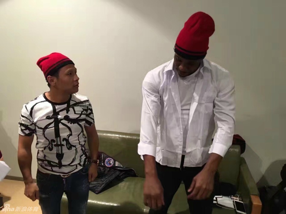 郭艾伦身穿绿色时尚风衣,一脸得意地站在中间,左右手分别搂着哈德森和宋小宝,三人对着镜头露出大白牙,画面十分有爱。