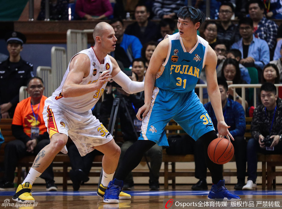 深圳队外援帕戈面对福建队员的贴身紧逼，凭借出色的运球技巧强行突破，高高跃起准备上篮。