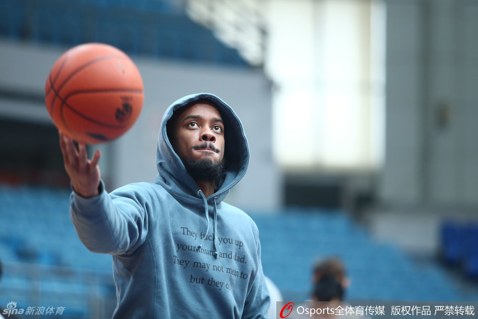 身披休闲帽衫的杰伦-布朗坐在场边休整,目光如炬地瞄准远处篮筐,放松姿态中难掩专注杀气