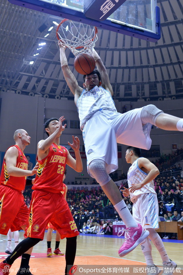 周琦在三分线外持球，面对深圳球员的贴防，他运球调整节奏，寻找投篮机会。