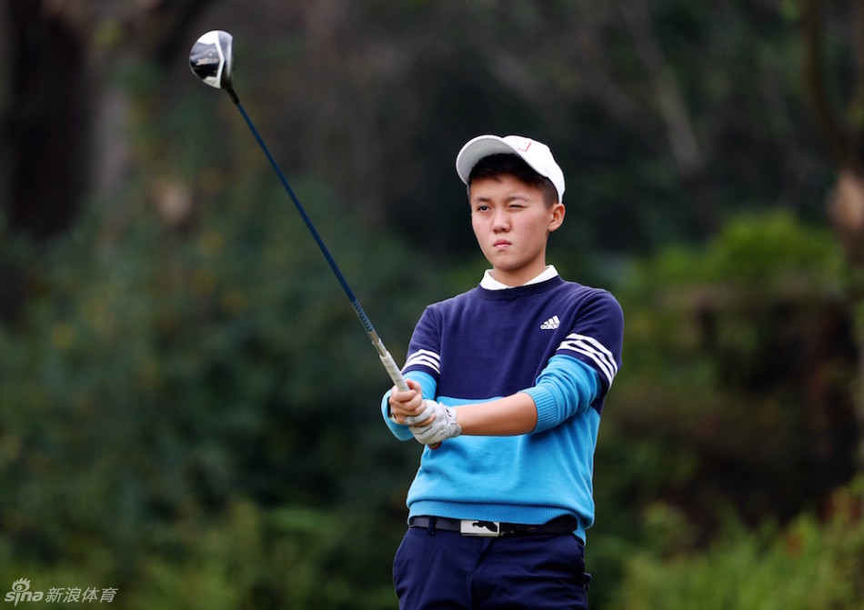 高尔夫少女韩雨岑手持高尔夫球杆，于绿茵之上展露自信而灿烂的微笑，身后是辽阔的赛场