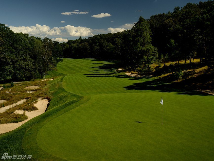 春日阳光下，奥古斯塔国家高尔夫俱乐部第12洞金钟花洞的静谧美景，碧水倒映着盛开的杜鹃花