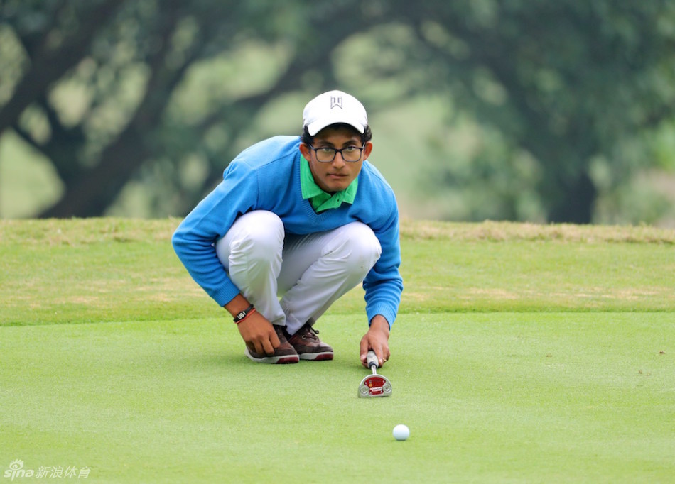 印度选手卡蒂-沙玛正聚精会神地观察果岭推杆线路,她的眼神专注,仿佛在计算着每一次滚动的细微变化。