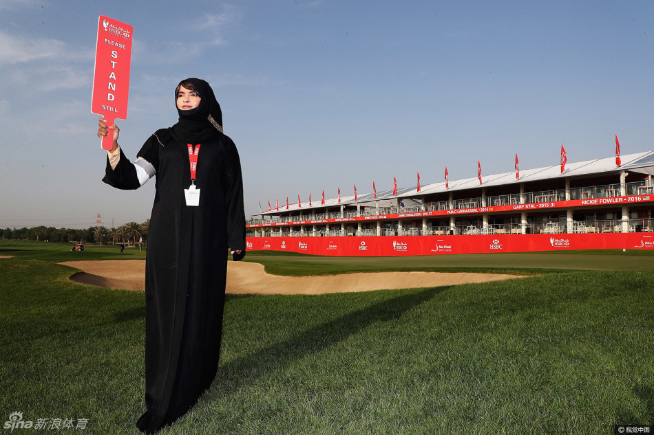 慈善发放现场,志愿者正将生活物资双手递给一位裹着头巾的妇女,眼神充满尊重