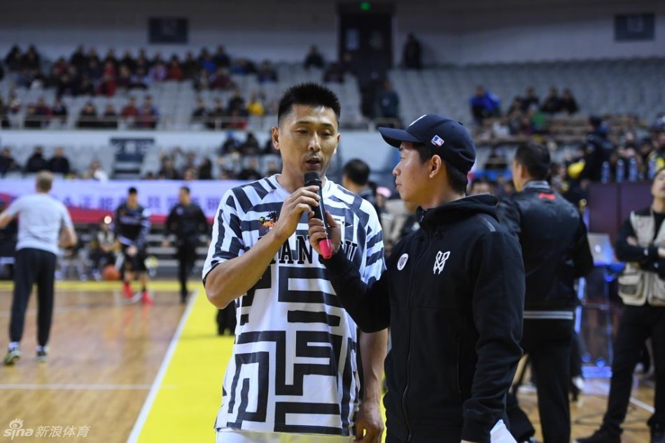 肯帝亚队长易立弯下腰,面带微笑地与坐在椅子上的小男孩轩轩亲切互动,轩轩穿着特制的小球衣,眼神中充满期待与喜悦。