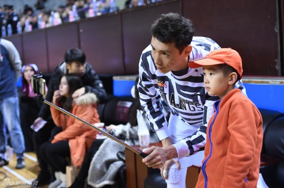 球场的绝佳观赛席位上,小轩轩在父母的陪伴下专注地观看比赛,脸上洋溢着纯真而开心的笑容,完全沉浸在篮球的快乐中。