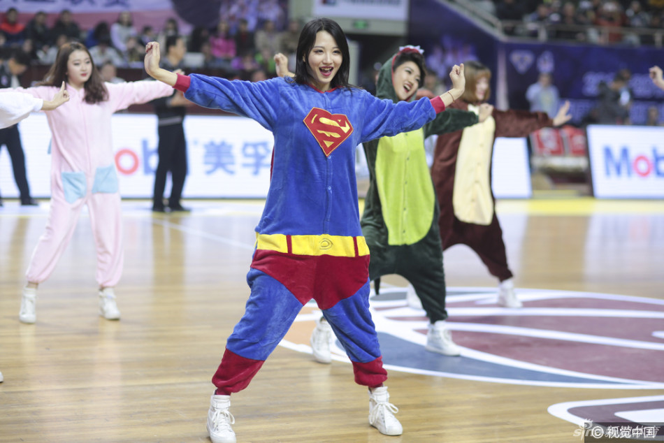 一位穿着红色超人披风睡衣的篮球宝贝,正对着镜头握拳鼓劲,眼神里带着还没睡醒的迷糊,却又努力做出严肃的表情,滑稽又可爱。