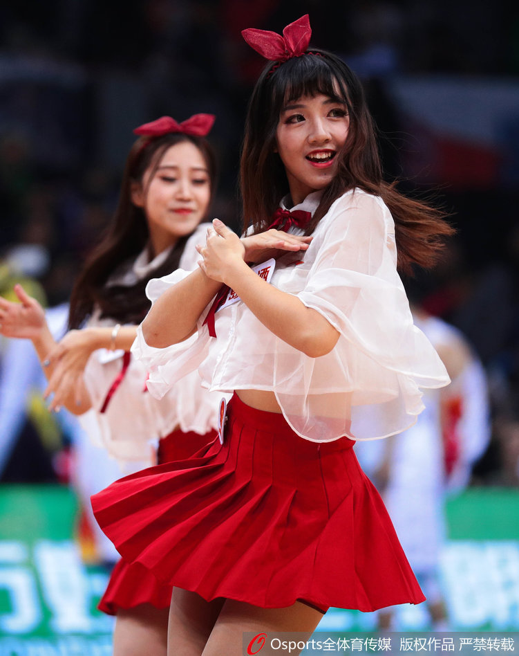 集体造型中，宝贝们错落有致地摆出优美姿态，红色的裙装在灯光下格外耀眼，她们的身姿与手中的花球构成一幅充满美感的画面。