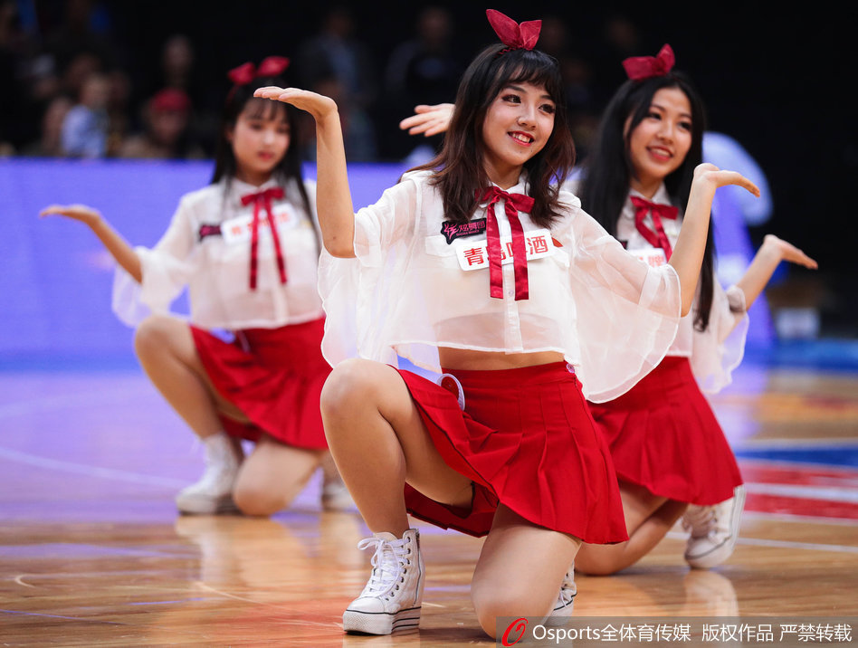 深圳篮球宝贝们身着烈焰般的红色短裙，在场上摆出整齐划一的队形，她们身姿挺拔，笑容灿烂，为激烈的比赛增添了一抹柔美与活力。