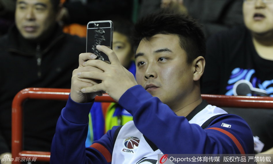 刘国梁在场边露出标志性的笑容，身前的辽宁队标牌格外醒目，这一刻他不再是严厉的教练。