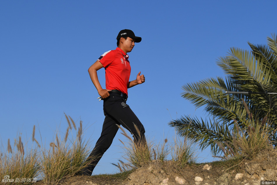 韩国球员王情训在长草中谨慎救球，身体姿态展现出对困难球位的全神应对