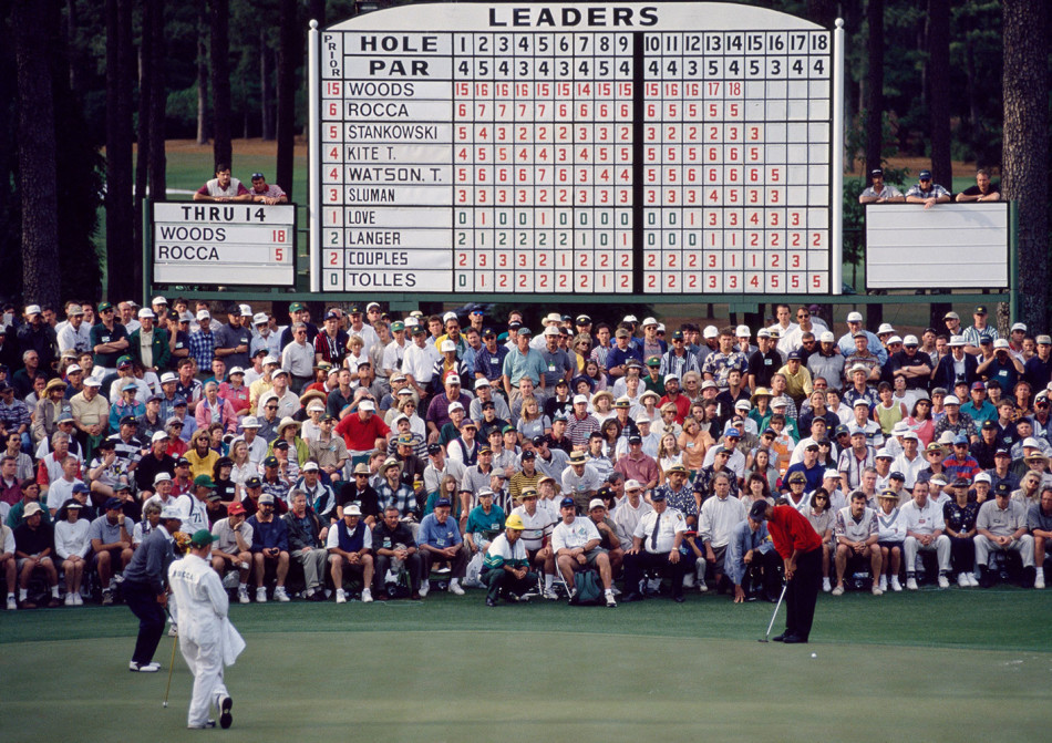 千禧之年，泰格·伍兹高举美国公开赛冠军奖杯，阳光洒在他自信的笑容与奖杯上，背后是圆石滩的海天一色