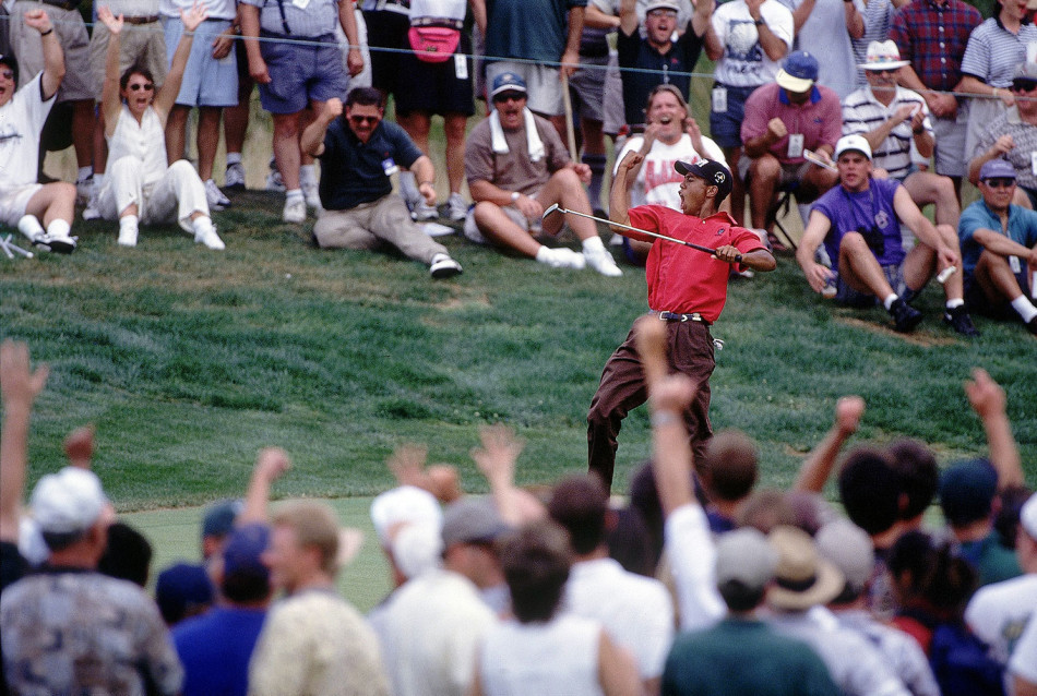 1997年美国大师赛，泰格·伍兹在奥古斯塔第18洞果岭推出致胜一推后，振臂庆祝，身后是欢呼的观众与历史的见证