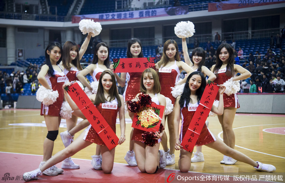 身着火红紧身衣的篮球宝贝扎着利落马尾,双手举起大红福字,眉眼弯弯笑得灿烂,身后虚化的篮球架映衬出她健康活力的身姿