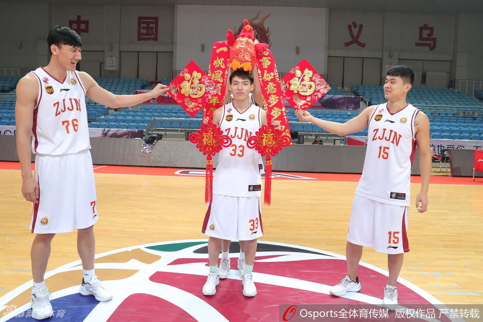 吴前、张永鹏、夏钰博三人并排举起‘恭喜发财’金字红底横幅，眼神里满是对新年的憧憬