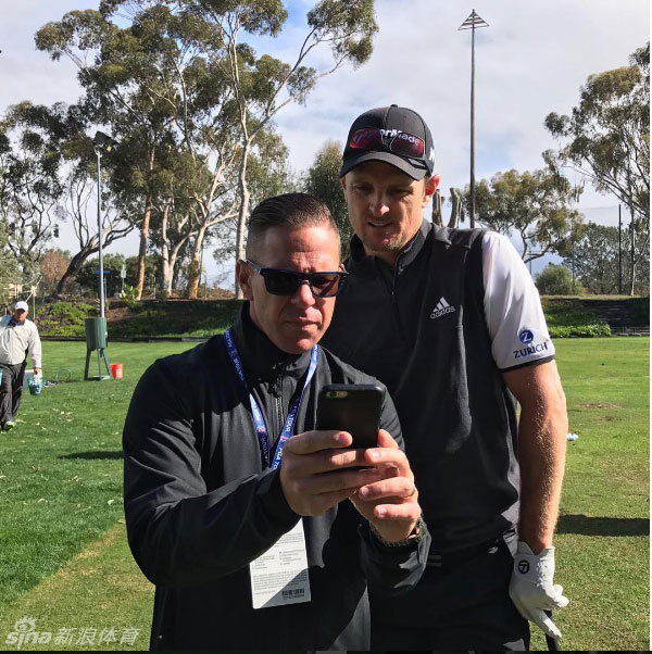 贾斯汀·罗斯与肖恩·弗利在练习果岭上并肩而立，轻松交谈，仿佛在分享一个只有彼此才懂的高球趣事