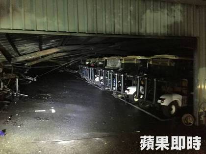 被大火彻底吞噬的仓库，屋顶严重塌陷变形，焦黑的框架犹如巨兽的骸骨，在烟雾中若隐若现。