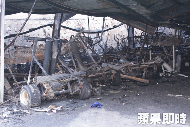 消防队员在已控制的火场废墟中进行后续清理工作，仔细排查可能复燃的隐患点。