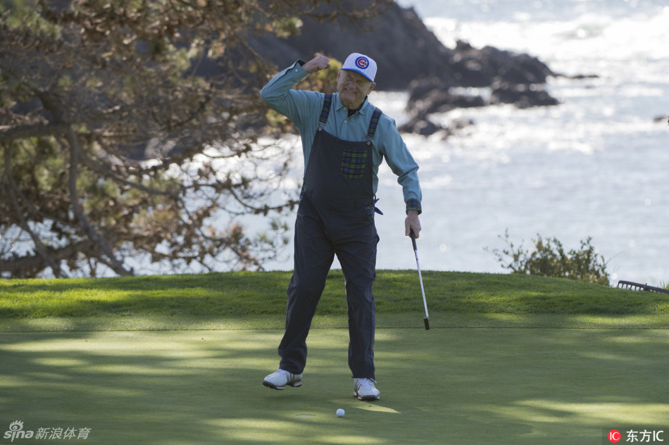 橄榄球巨星阿隆·罗杰斯凝神观察推杆线路，竞技体育的专注精神在高尔夫场上再次闪耀。