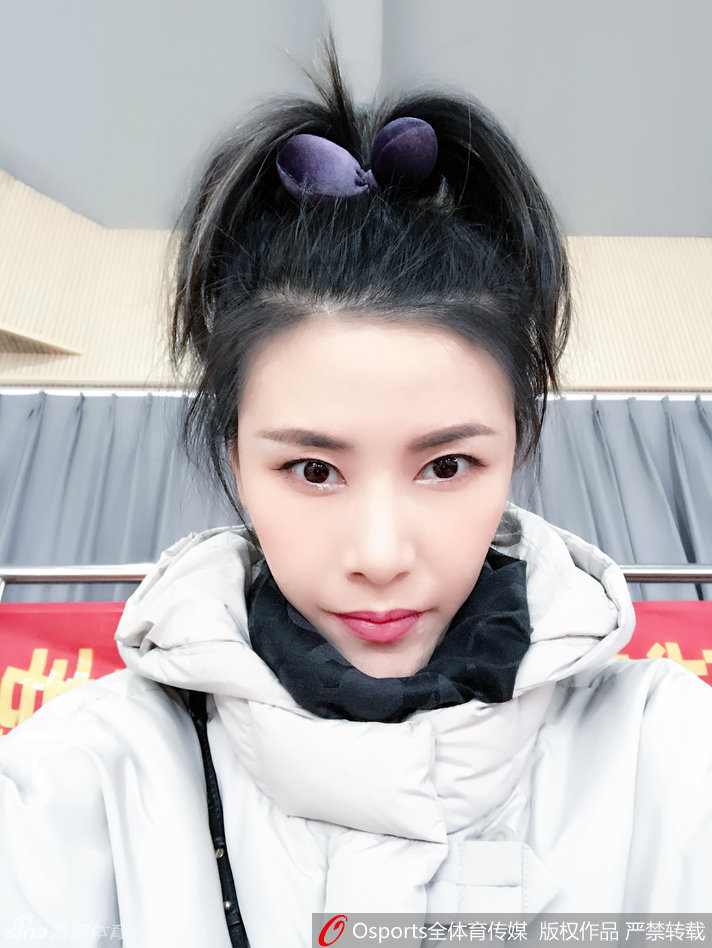 许诺身穿黑色运动装，在训练馆中专注地进行拉伸，身体的柔韧性展露无遗，仿佛在诉说着一个运动员背后日复一日的坚持与自律。