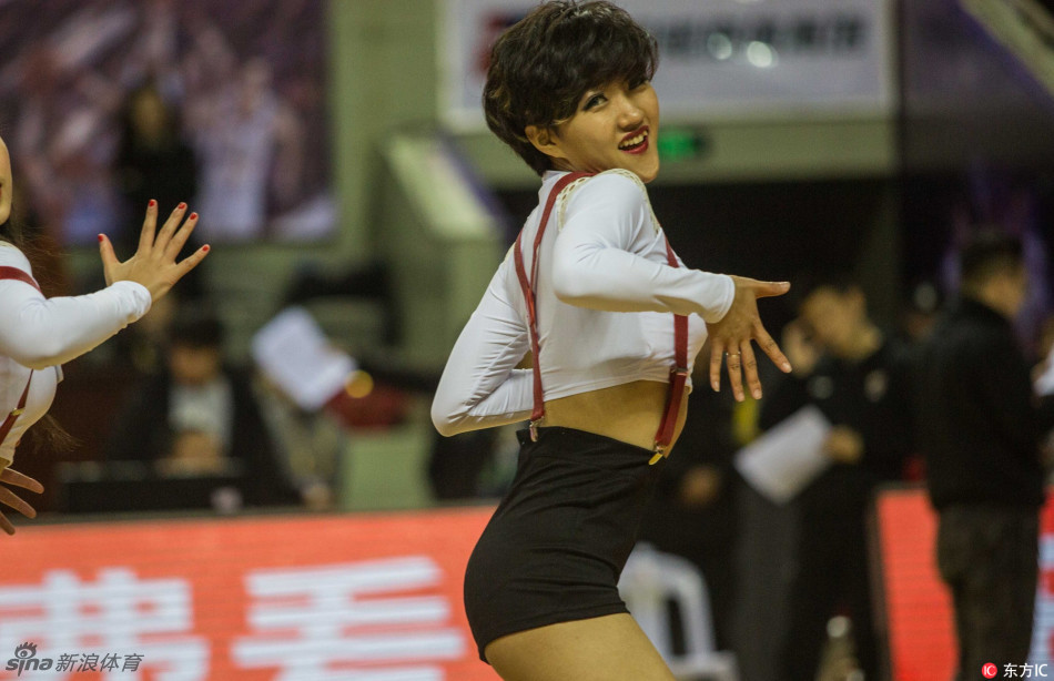 两位拉拉宝贝背对背斗舞，动作俏皮充满互动感，身后是热情挥舞的球迷，现场成了欢乐的海洋。