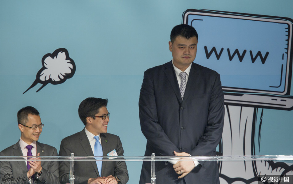 在论坛的贵宾交谈区，姚明双手抱在胸前，以他独有的身高优势俯身与霍启刚交谈，霍启刚则微微仰头神情专注，画面生动展现了两位不同领域领军人物之间的思想碰撞。