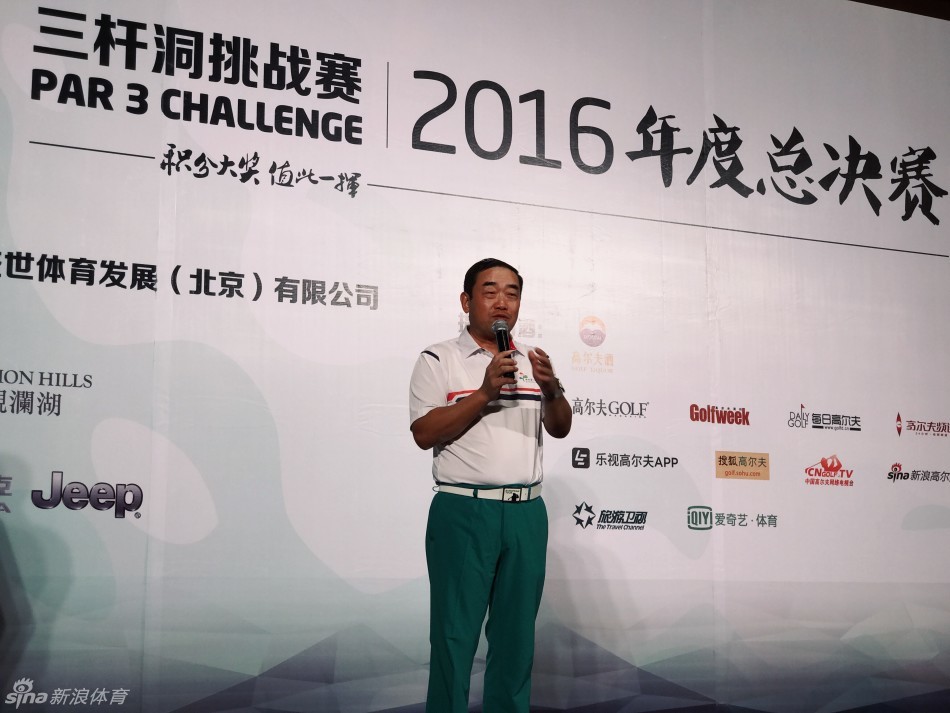 王志刚先生在晚宴上发表致辞，神情从容自信，手持话筒向全场嘉宾阐述赛事理念，背后是巨大的赛事背景墙。