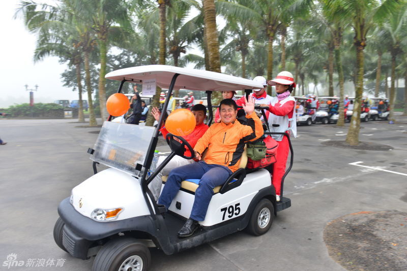 演员石文忠与丁志诚在果岭边轻松交流，笑容满面，享受高尔夫运动带来的纯粹乐趣