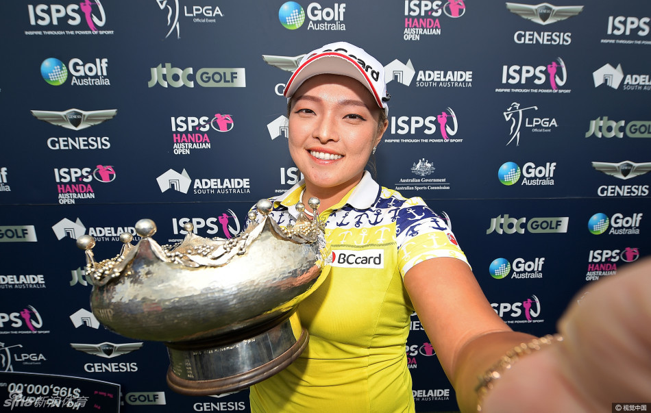 张哈娜俏皮地将冠军奖杯顶在头上，双手扶稳，眼神中闪烁着自信与顽皮的光芒，以独特方式庆祝胜利时刻