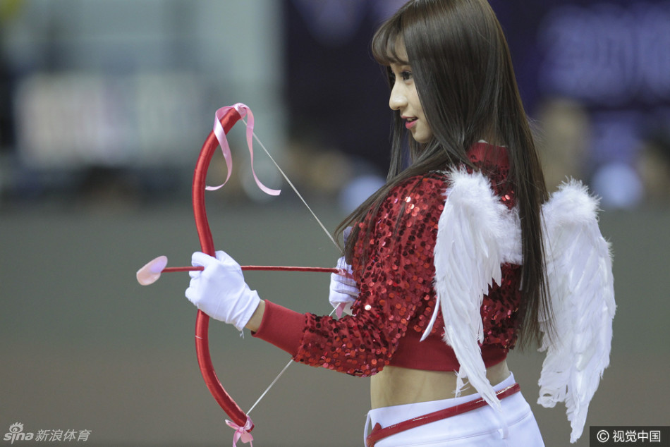 舞台中央，一位萌系装扮的“福女”手捧鲜花，对着镜头露出甜美笑容，并俏皮地比出剪刀手，显得既可爱又喜庆。