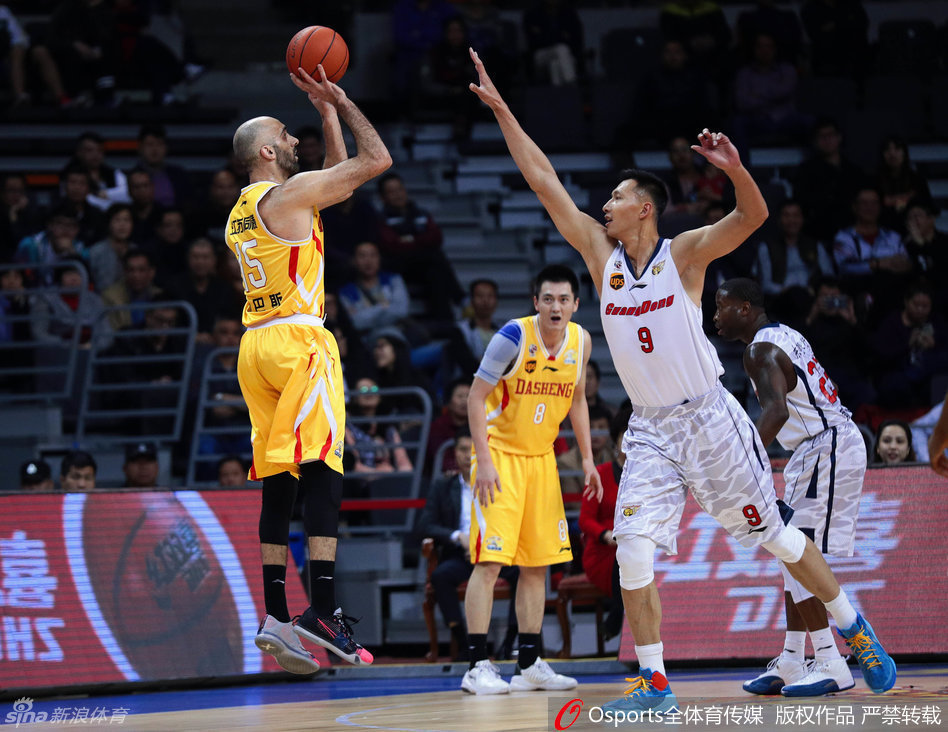 迪奥古在肌肉丛林中高高跃起，双手如铁钳般紧紧抓住篮板，滞空瞬间展现出惊人的核心力量，强硬的姿态宣告着对内线禁区的绝对主权。