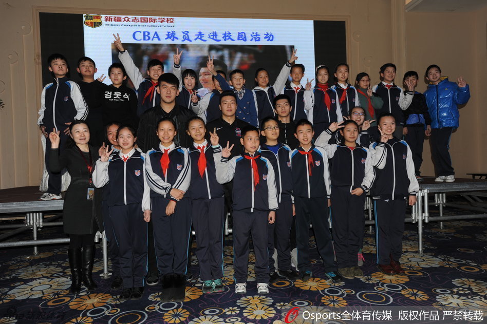 李根坐在椅子上，身体微微前倾，正专注地为排队的孩子们一一签名。他的身后，是安静的校园走廊，而他的面前，是一条长长的队伍，每一张递过来的纸上，都写满了对未来的期许。