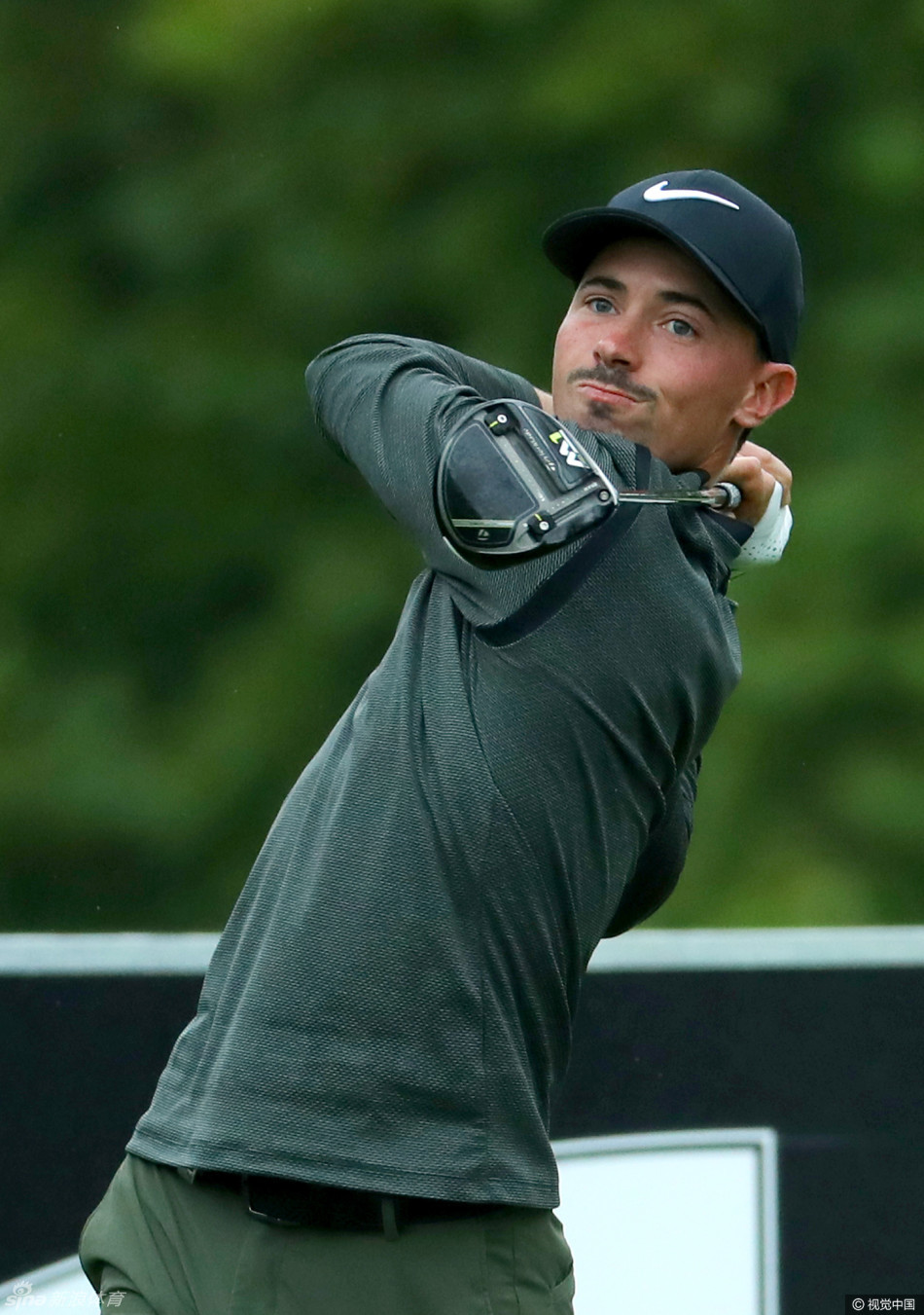 球员在开球前仔细审视球道，远处斯泰伦博斯独特的山景与精心养护的果岭构成一幅挑战与美景并存的画面。