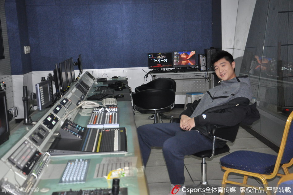 导播间内，身穿休闲装的李敬宇双手插兜，好奇地观察着满墙的监视器和忙碌的工作人员，他对电视节目的制作流程充满了新鲜感，脸上挂着憨厚的笑容。