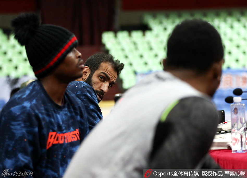 主教练杨学增拿着战术板双手比划着对球员们大声训话,队员围成一圈神情严肃认真聆听