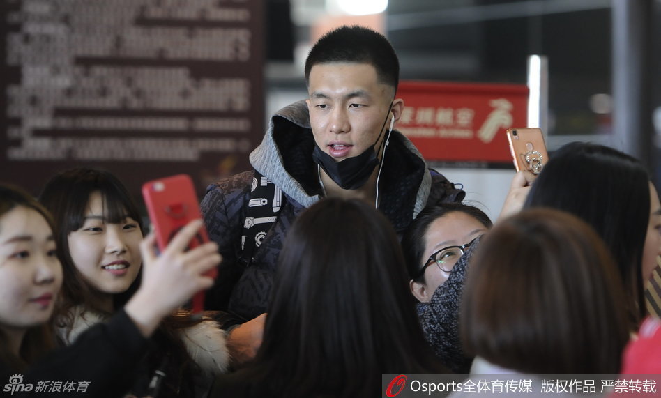 郭艾伦被里三层外三层的球迷团团围住，他微微低头为身前的小球迷在球衣上签名，嘴角挂着标志性的腼腆笑容