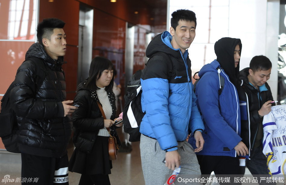 哈德森一边推着行李箱，一边与赵继伟玩起击掌游戏，两人表情搞怪，身后的李晓旭和钟诚也露出灿烂笑容