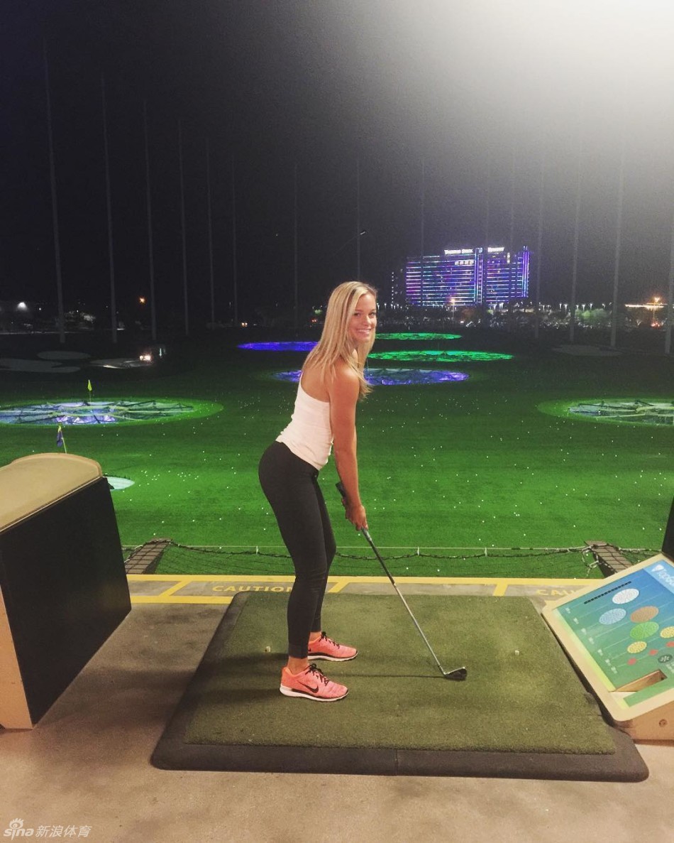 肯德尔在海边岩石上展现其健美的后背肌肉线条，阳光照射下充满力量与雕塑感