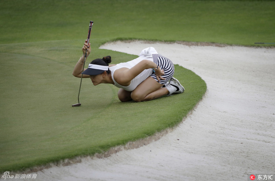 冯珊珊深陷沙坑困境，正全神贯注准备救球，手中的挖起杆蓄势待发