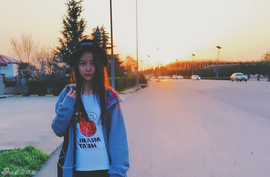 夕阳的余晖洒满空荡的球场，身穿23号球衣的女孩凝望着高高的篮筐，她的身影被拉长，眼神里写满了对扣篮的渴望与坚定。