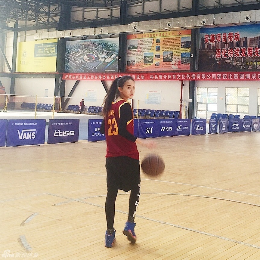 女孩紧紧抱着心爱的篮球，脸上洋溢着纯真而灿烂的笑容。背景是模糊的球场和夕阳，她的眼神明亮，仿佛透过镜头，看到了自己未来扣篮成功的模样。