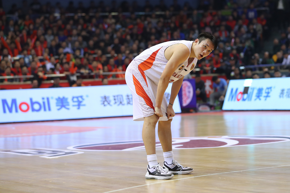 丁彦雨航从颁奖嘉宾手中接过象征荣耀的MVP奖杯，眼神中闪烁着自信与坚毅，全场球迷起立为他欢呼。