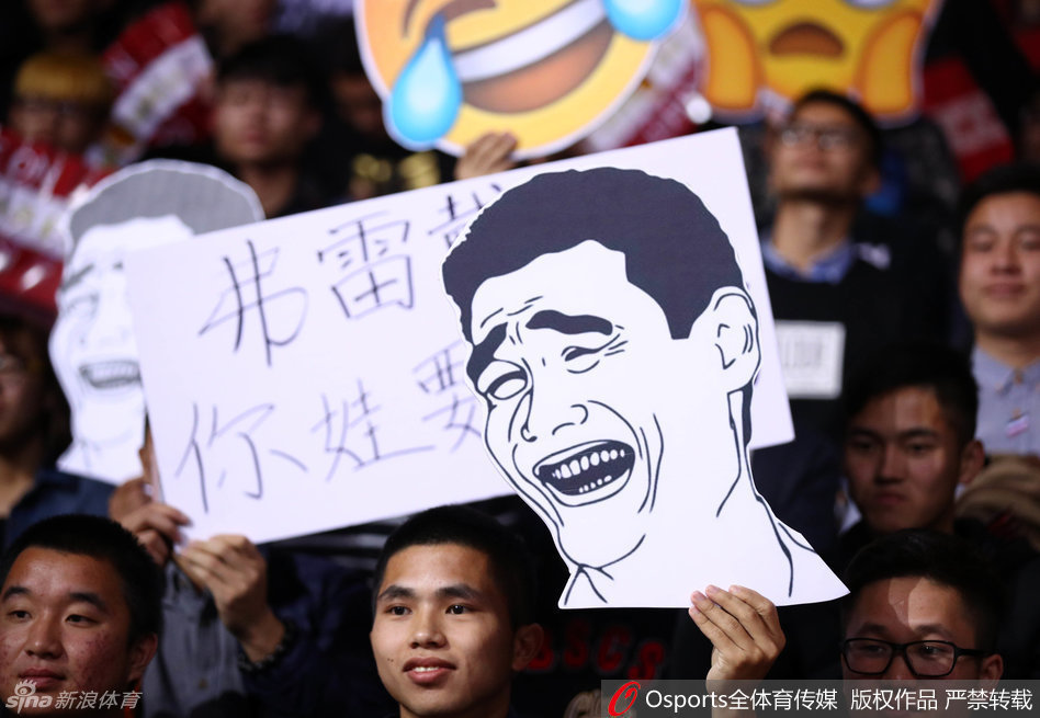 一位身穿深圳队球衣的男球迷举起手中的助威牌，上面用醒目的字体写着‘深圳烈豹 碉堡了’，简单粗暴地表达了对主队战斗力的自豪与赞叹。