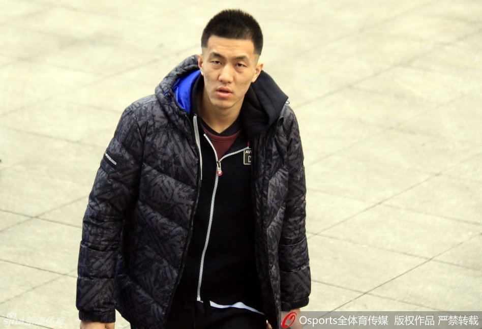  郭艾伦眼神有些迷茫地坐在场边，双手抱着篮球，表情呆萌可爱，与场上激烈的备战节奏形成了一种有趣的反差萌。