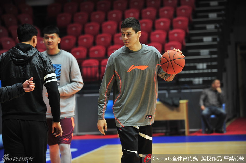 队长阿不都沙拉木与队友李根在训练间隙认真探讨战术配合,两人用手比划着跑位路线,神情专注。