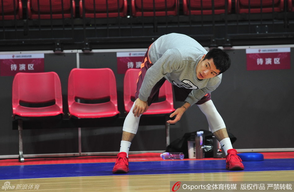 替补后卫王子瑞在球场边线处认真地进行着运球和拉伸热身,随时准备听候教练的召唤。