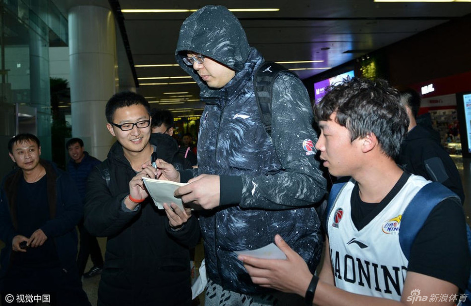 身材魁梧的韩德君被热情的球迷紧紧包围,他手拿一件白色T恤,脸上挂着憨厚而亲切的笑容,耐心地满足着大家签名合影的请求,场面如同巨星见面会。
