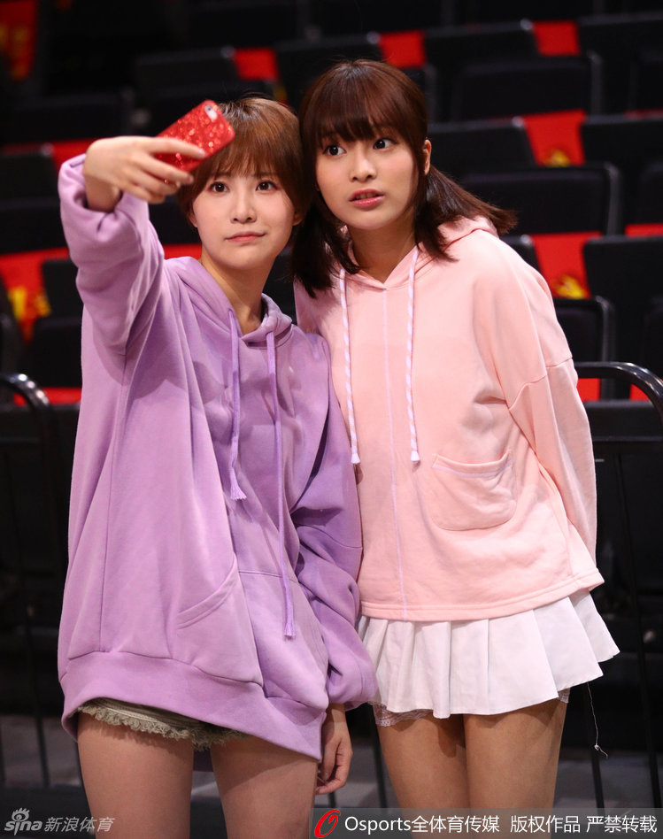 演出结束后，GNZ48成员们对着镜头比出招牌剪刀手，身后的背景是深圳龙岗大运中心巨大的CBA季后赛横幅，少女与赛场构成了一幅充满反差萌的生动画面。